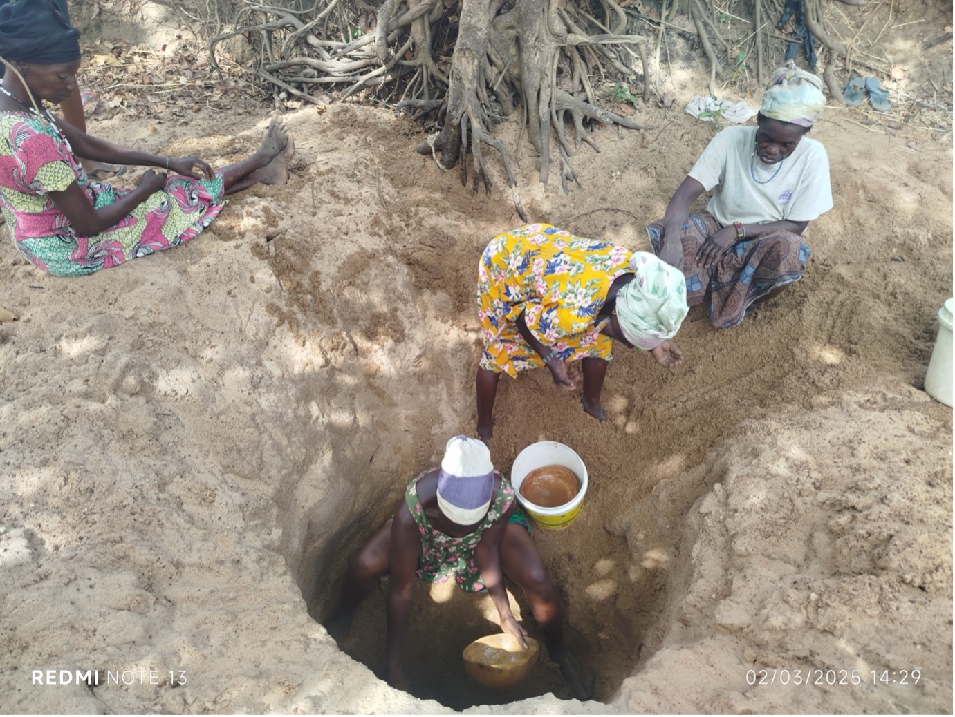 Community members collecting water from the dry river bed